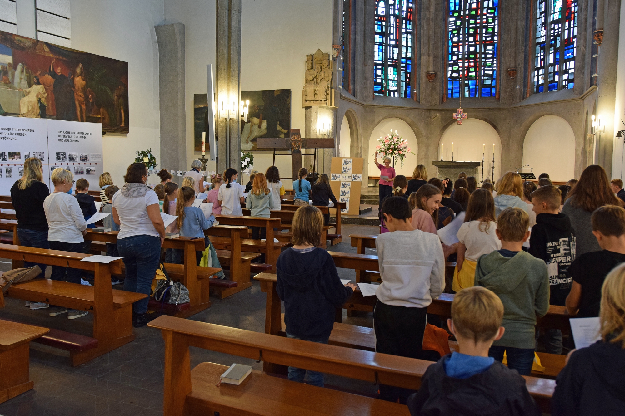 Ein ideenreicher, bewegender ökumenischer Gottesdienst im Zeichen des Aachener Friedenskreuzes: zwei fünfte Klassen des St. Ursula-Gymnasiums in St. Foillan.